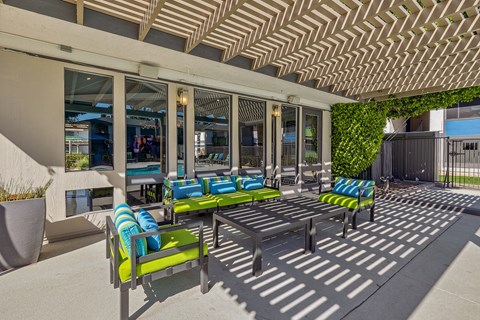 a patio with blue and green chairs and a table